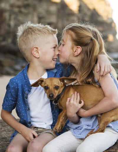 two children sharing a moment with their dog