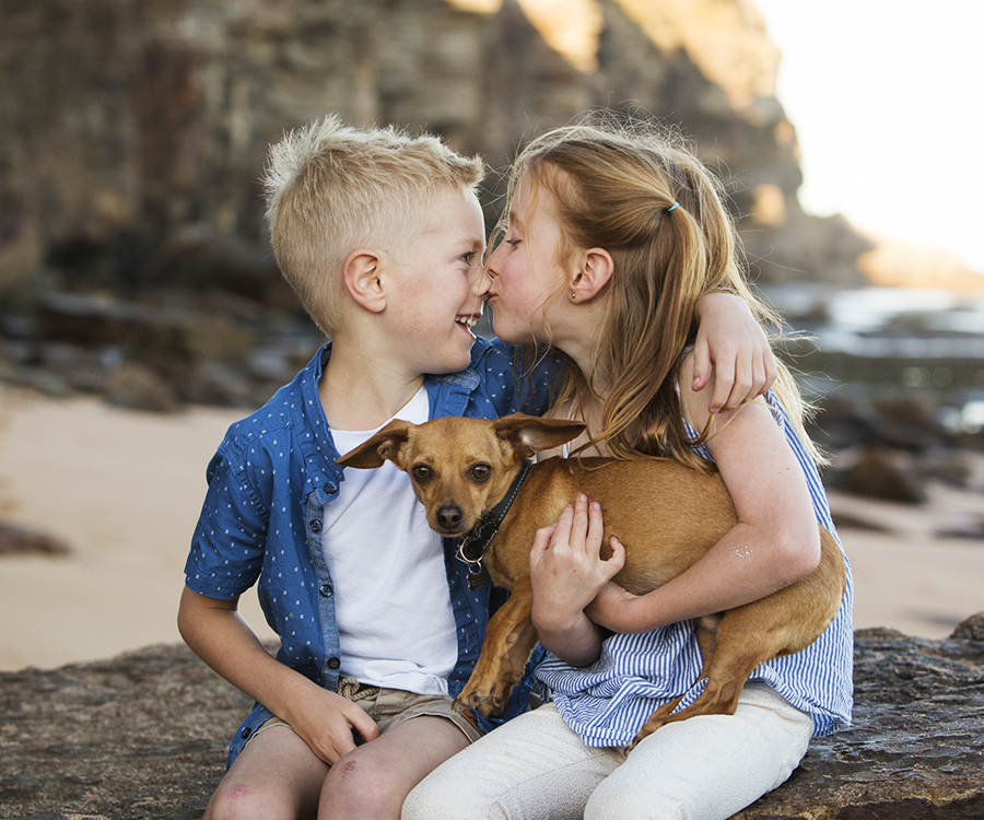 two children sharing a moment with their dog