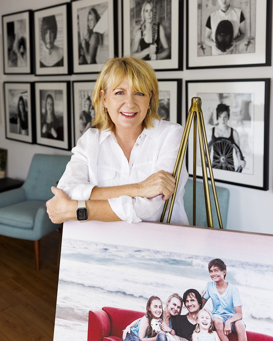 Carol Gibbons standing in her studio surrounded by her award winning photos 